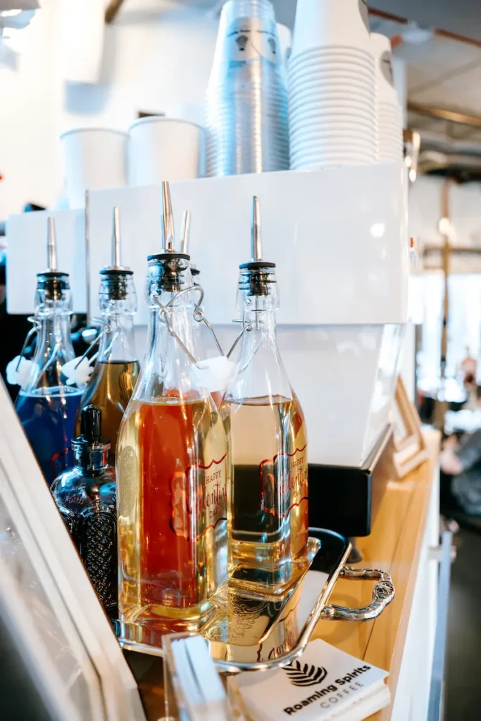 Bottles of coffee syrups on top of a Roaming Spirits Coffee espresso cart