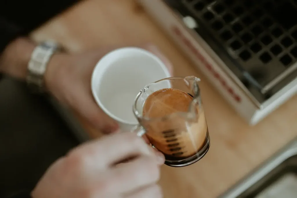 A person holding a shot of espresso.