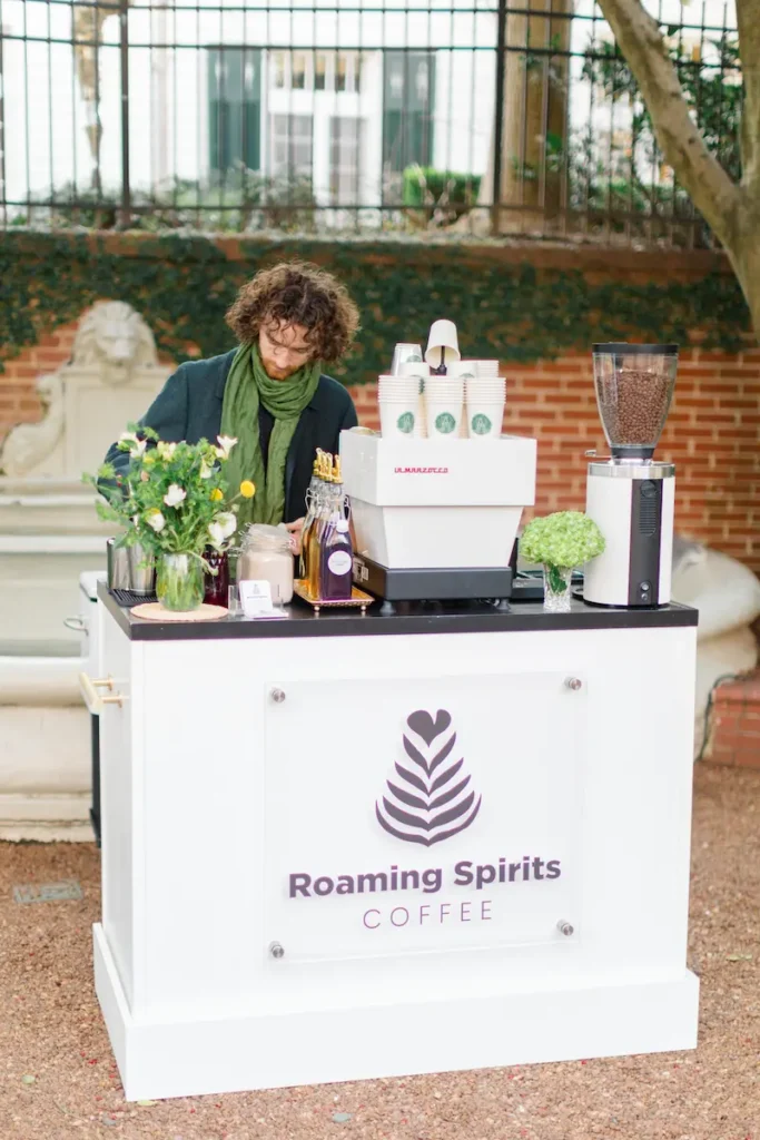 A barista making coffee behind a Roaming Spirts Coffee at the Duke Mansion