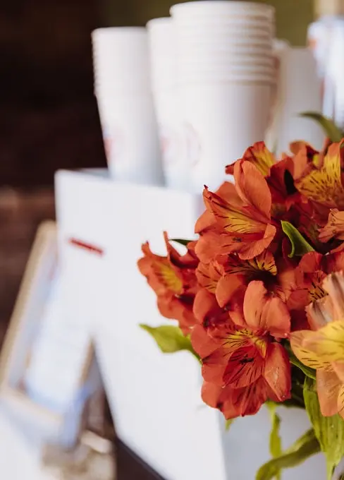 Orange flowers with an espresso machine behind it