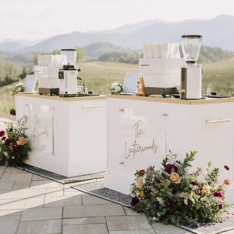 Two custom Roaming Spirts Coffee espresso cart with light wood bar tops outdoors at a private wedding event