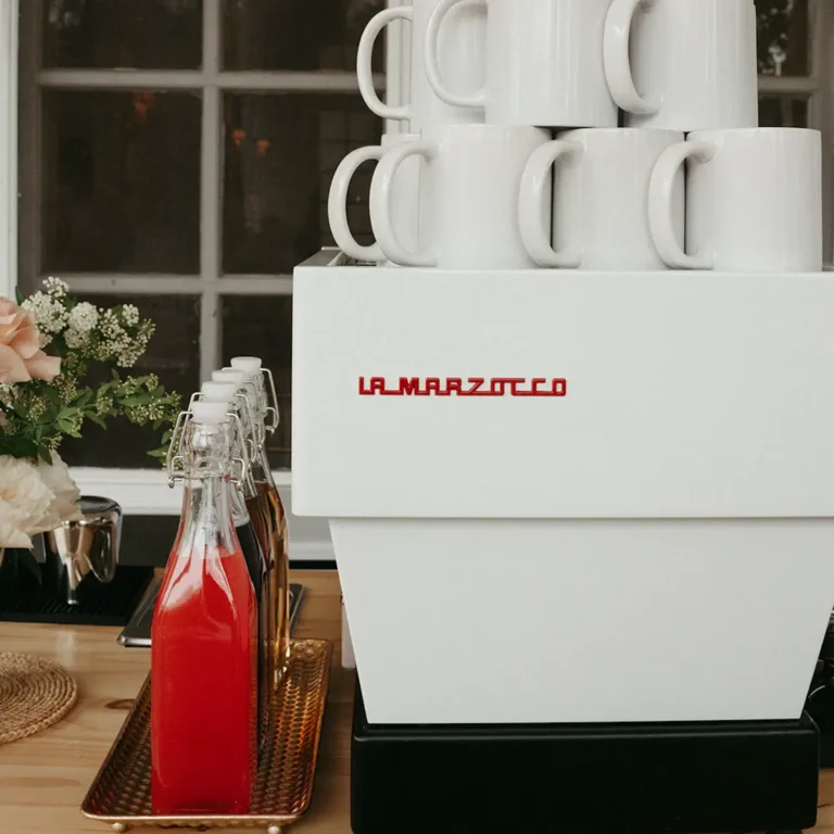 Espresso machine with coffee syrup bottles next to it.